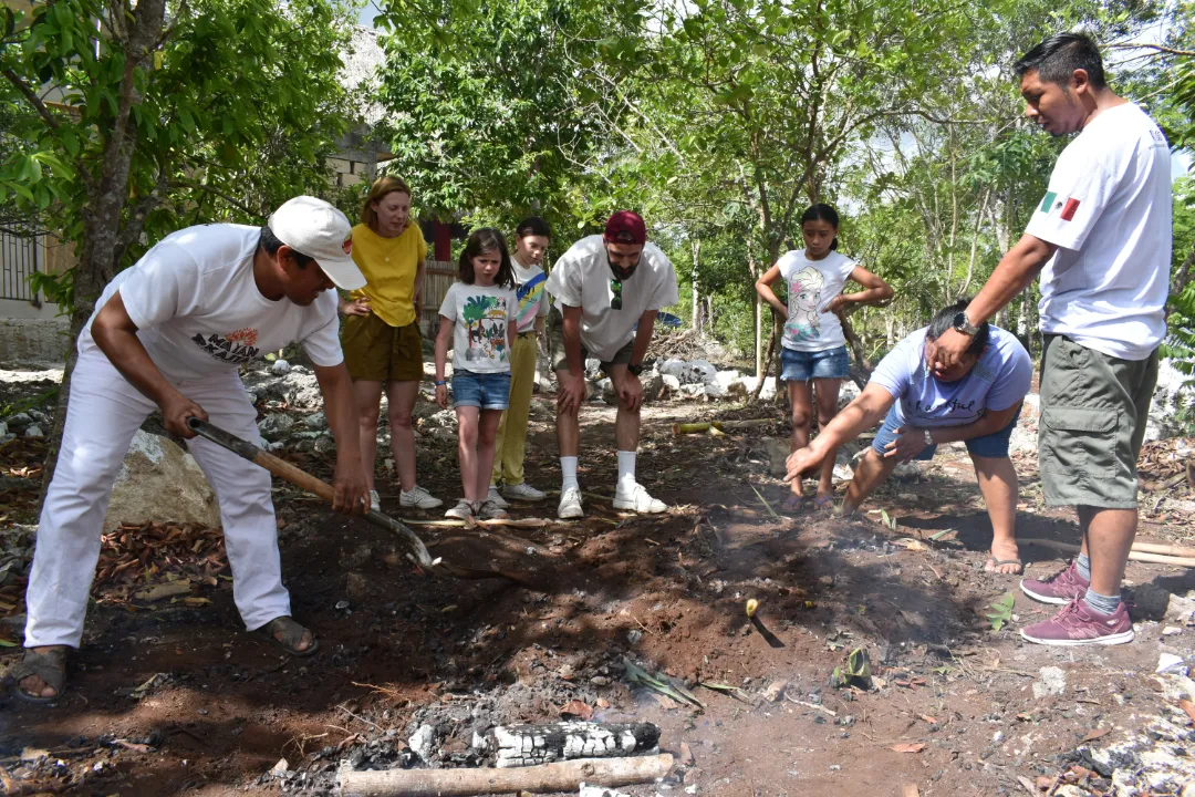 Personas realizando un pib maya de manera tradicional