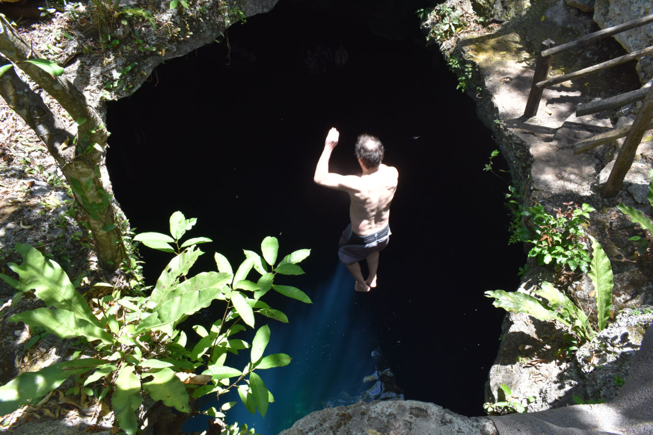 hombre saltando al cenote en Coba