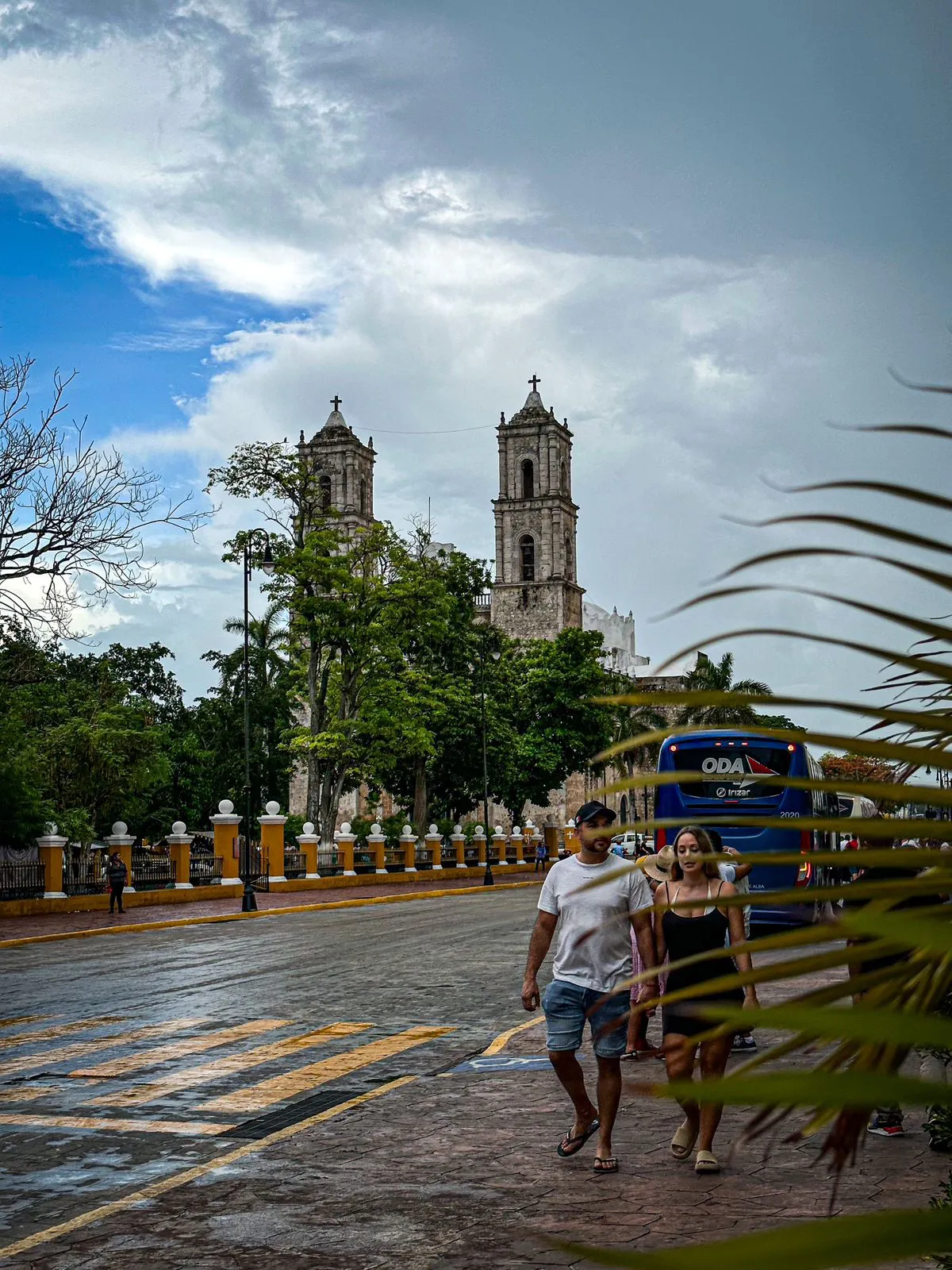 dos turistas caminando y la iglesia de Valladolid de fondo